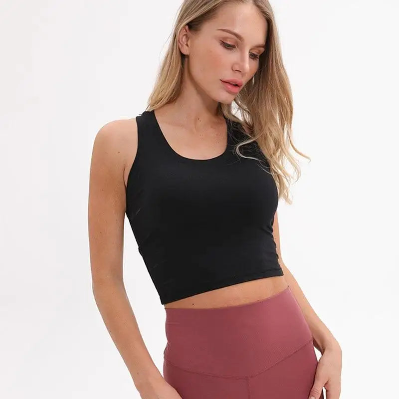 Femme portant un top noir et un pantalon taille haute bordeaux.