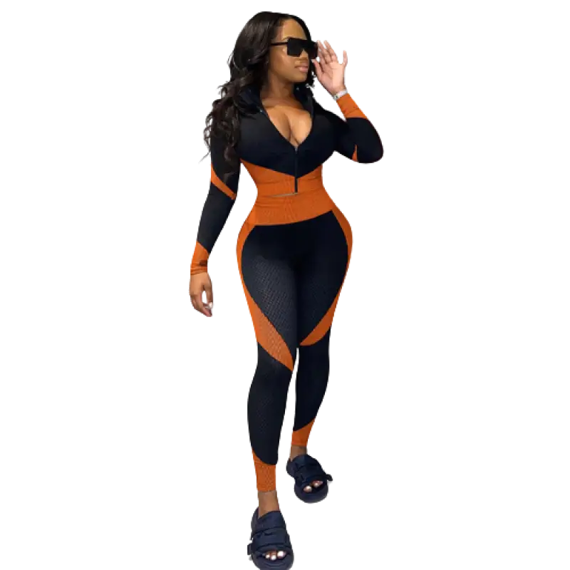 Femme portant une tenue de sport moulante noire et orange et des lunettes de soleil.