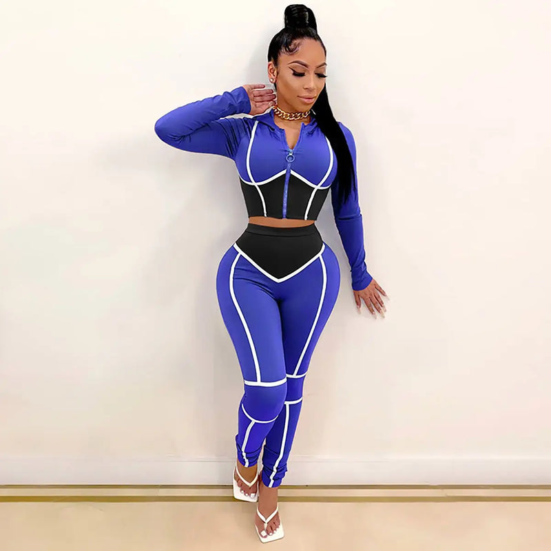 Femme portant une tenue de sport moulante bleue et noire avec des bordures blanches.