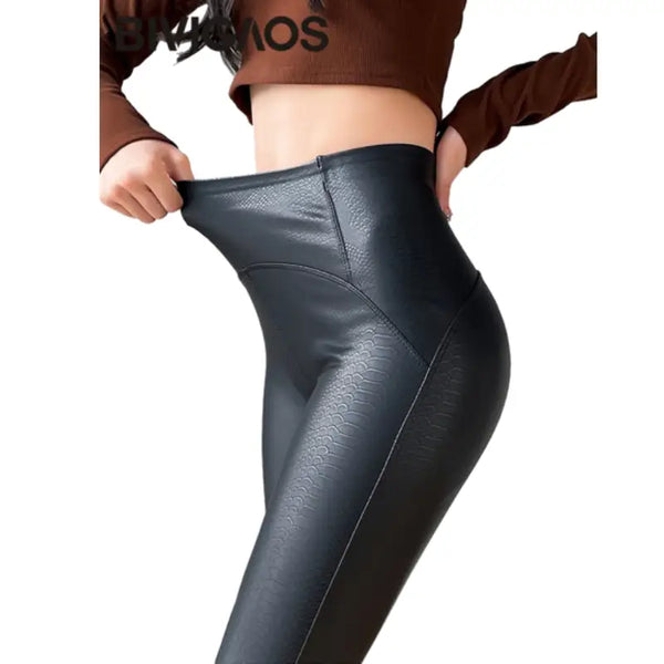 Des leggings ou des pantalons en cuir noir brillant tirés à la taille.