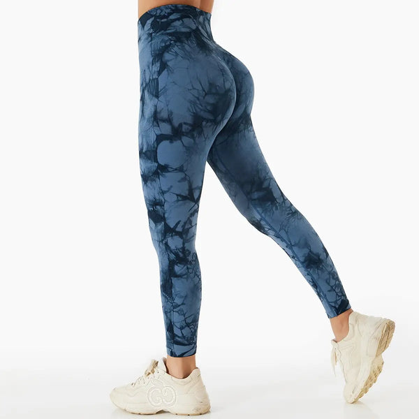 Legging bleu à motifs tie-dye porté avec des baskets blanches.