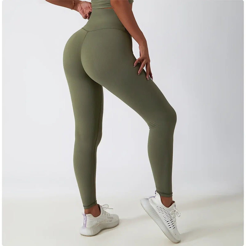 Un legging de sport vert olive à taille haute porté par une personne.