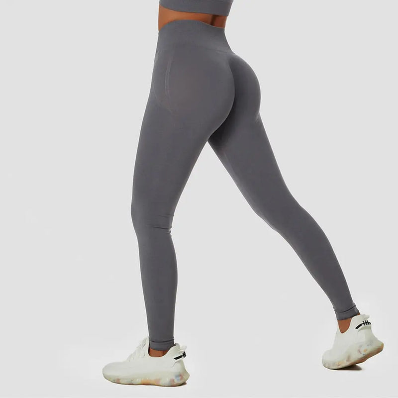 Leggings d’athlétisme gris à taille haute portés avec des baskets blanches.