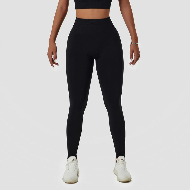 Leggings athlétiques noirs à taille haute portés par une femme.